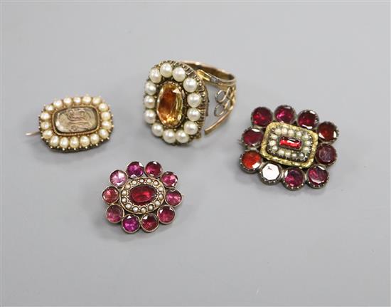 A 19th century yellow metal and seed pearl mourning brooch, two Victorian garnet brooches and an early 19th century ring.